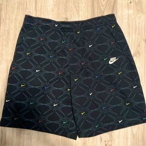 Nike shorts. Black multicolored swooshes. Knee length standard fit. New w/ tags